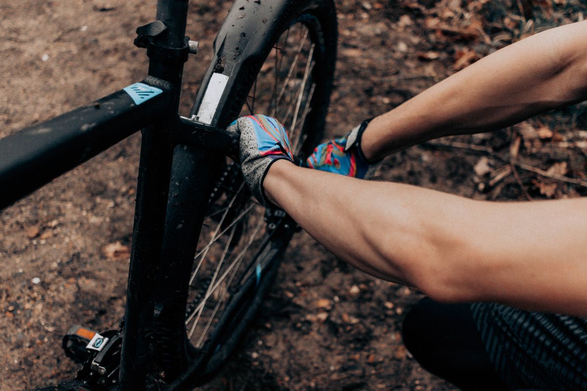 Mechanik centruje koleso bicykla v dielni Bicyklora